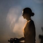 Mulher praticando meditação mindfulness ao amanhecer - técnicas do aqui e agora