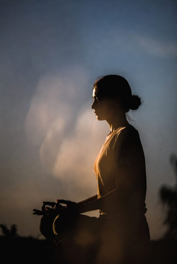 Mulher praticando meditação mindfulness ao amanhecer - técnicas do aqui e agora
